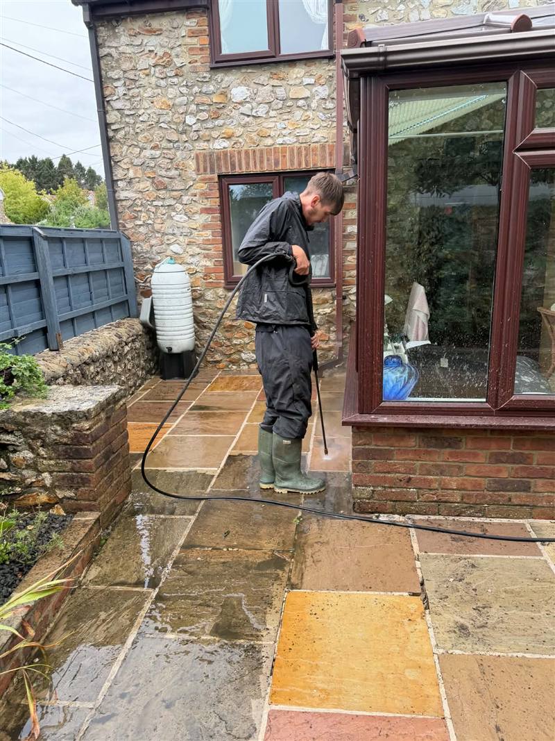 Pressure washing a patio at a stone cottage